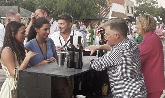 Kevin Mills, of Napa, Calif., right, seen with Brandy Leonard, serves up his 2021 Mills Cabernet to eventgoers the Third Annual Wine Down on False River. Photo by John Dupont