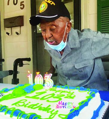 Leon Dixon blows out candles on the celebration of his 103rd birthday in this 2021 photo.